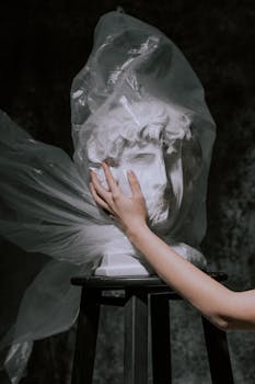A gypsum sculpture wrapped in plastic, symbolizing pollution and waste.