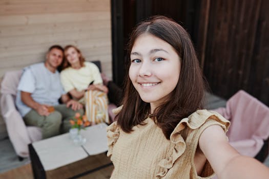 A smiling teenage girl taking a selfie with her parents outdoors, capturing a joyful family moment.