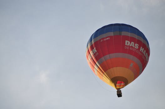 Vibrant hot air balloon flying high against a clear blue sky giving a sense of adventure.